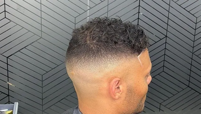 Curly top with a high skin fade